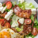 Fresh ketogenic salad with bacon, egg, feta, and tomatoes, perfect for healthy eating.