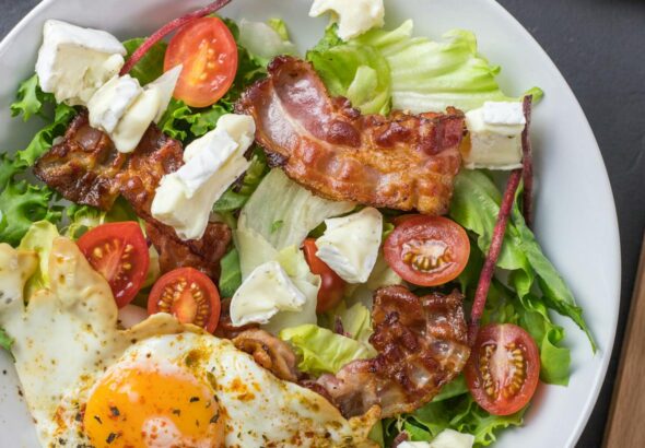 Fresh ketogenic salad with bacon, egg, feta, and tomatoes, perfect for healthy eating.